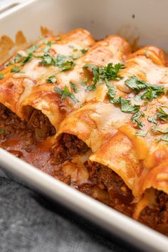 a casserole dish with meat, cheese and sauce in it on a table