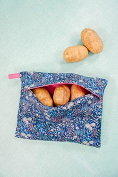 two potatoes sitting in a blue bag on top of a table