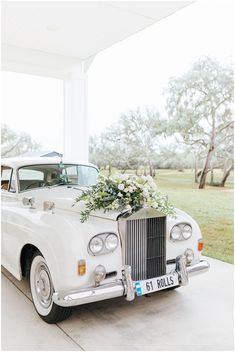 a wedding car with flowers on the front