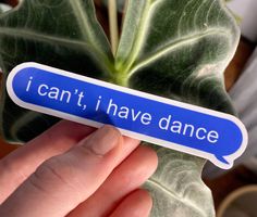 a hand holding a blue sticker that says i can't i have dance