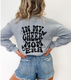 ** Custom Cheer Mom Sweatshirt, Retro Cheer Era Sweatshirt, Gift for Mom, Cheerleading Sweatshirt Gildan 18000, Cheer Mom Gift Personalized** This sweatshirt will really show your cheerleader how much you support them. This personalized Cheer Mom sweatshirt is a nice medium weight material, with the softest and coziest feeling inside. The design is printed directly into the fabric, so you will never have to worry about peeling or cracking! This style does give your sweatshirt a more distressed/w School Spirit Graphic Print Top For Winter, Casual Tops For Cheerleading In Fall, School Spirit Long Sleeve Sweatshirt With Graphic Print, School Spirit Graphic Print Long Sleeve Sweatshirt, Cheerleading Tops For Fall, Long Sleeve Screen Print Top For College, Relaxed Fit Long Sleeve Tops With Lettering, School Spirit Screen Print Tops For Fall, Fall School Spirit Screen Print Tops