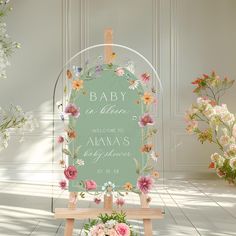 a baby is born sign with flowers on it