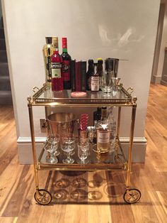 a bar cart filled with liquor bottles and glasses