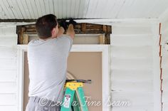 a man is working on the ceiling in his house