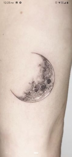 a small tattoo on the side of a woman's thigh with a half moon