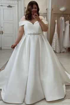 a woman is taking a selfie in her wedding dress while looking into the mirror