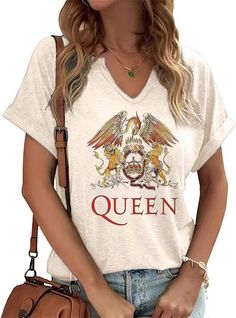 a woman wearing a white t - shirt with the word queen printed on it and holding a brown purse