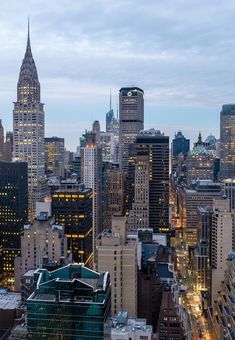 the city skyline is lit up at night, with skyscrapers in the foreground