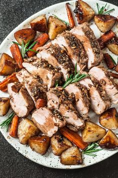 a white plate topped with meat, potatoes and carrots