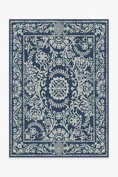 a blue and white rug with an intricate design on the bottom, in front of a white background