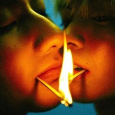 two children kissing each other with a lit match between them