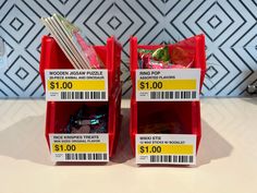 two red bins filled with candy sitting on top of a counter next to each other