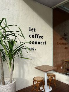 a table and two chairs sitting on a wooden floor in front of a wall that says let coffee connect us