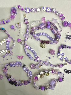 purple beads and charms are laid out on a table