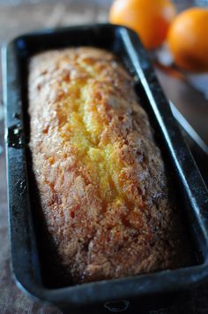 a loaf of bread sitting on top of a table next to oranges