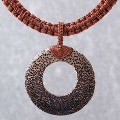 a close up of a piece of jewelry on a necklace with an oval pendant hanging from it