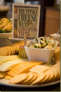 a plate full of cheeses and crackers with a sign on the side that says, the stinky cheese man