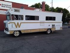 an rv parked in front of a building