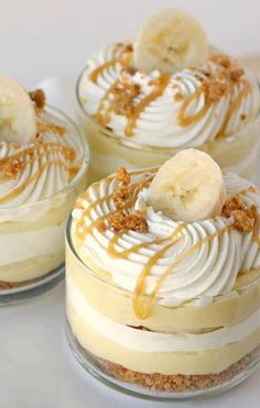 two desserts with bananas and whipped cream on top are sitting next to each other