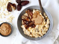 a bowl filled with oatmeal and raisins next to a spoon