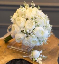 a bouquet of white flowers sitting on top of a wooden table