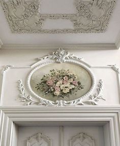 an ornate white door with flowers on it