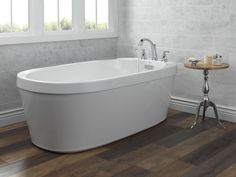 a white bath tub sitting on top of a wooden floor