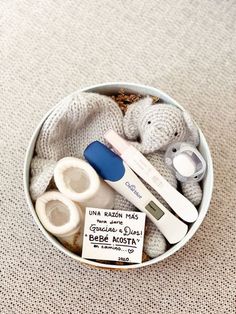 a small white bowl filled with baby items