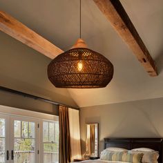 a large bed sitting under a wooden beam in a bedroom next to a sliding glass door