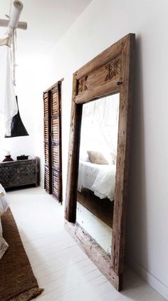 a bedroom with a bed and mirror in it