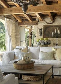 a living room filled with white furniture and lots of pillows on top of it's couches