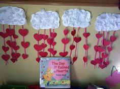 some paper hearts hanging from the side of a wall next to a book and other items