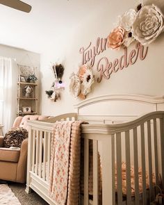 a baby's room with a crib and flowers on the wall