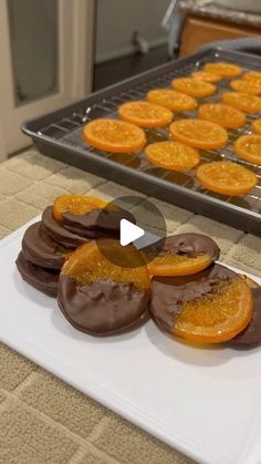 chocolate covered oranges on a white plate in front of a baking tray with an oven