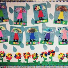 a bulletin board with paper cut out of children's umbrellas and flowers on it