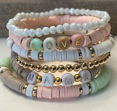 "Custom Word Heishi Stack Bracelets / Pastel Beaded Heishi Bracelets \"MAMA...LOVE...FAMILY\" Fun!  Trendy!  So Pretty! *Listing includes one bracelet  *Option to choose 1 or more bracelets *Let me know your choice of 7 bracelets (A,B,C,D,E,F,Gold) in the Note to Seller box at checkout.  *Customize by choosing Words to replace \"MaMa\", \"Family\", \"Love\"   in the personalization box. If no words chosen you will receive the default words shown. *Placed in a burlap drawstring bag (or a gift box Heishi Bracelets, Clay Bead Necklace, Preppy Bracelets, Homemade Bracelets, Stack Bracelets, Christian Bracelets, Preppy Jewelry, Sterling Silver Bead Bracelet, Bead Charms Diy