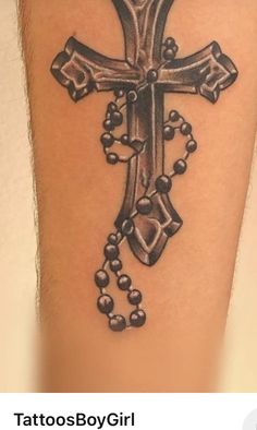 a tattoo with a cross and beads on it