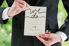 a person in a suit holding up a piece of paper with the word we do written on it