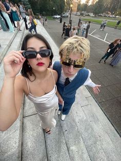 two women with sunglasses on their faces standing next to each other