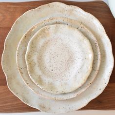 a stack of white plates sitting on top of a wooden table