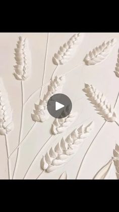 an image of some white flowers and leaves on the wall in front of a window