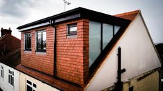 a red brick building with two windows on the roof