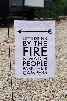 a sign that says let's drink by the fire and watch people park their campers