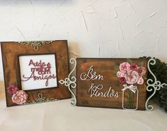 two wooden frames with flowers on them sitting next to each other