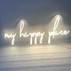 a neon sign that says, my happy place on the side of a white wall