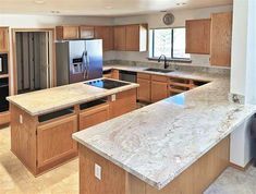 an empty kitchen with granite counter tops and wooden cabinets