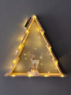 a light up triangle shaped shelf with lights on it and a deer figurine