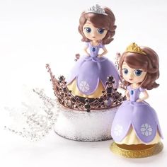 two little princess figurines sitting on top of each other