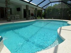 an empty pool in the middle of a house with a glass roof and sunlit patio area