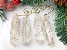 three pieces of wire wrapped in clear quartz sitting on top of a white marble counter